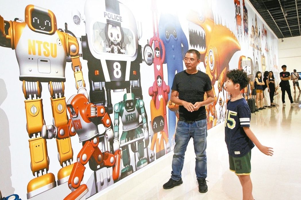 AKIBO機器人原創設計者李明道（左），昨耐心擔任「機器人爸爸」對現場小機器迷講解。 記者魏翊庭／攝影